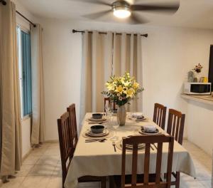 a dining room table with a vase of flowers on it at Casa San Pedro in Mérida