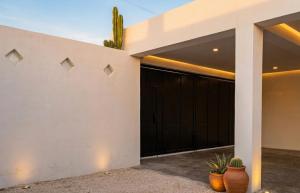 a garage with black doors on a house at Casa San Pedro in Mérida