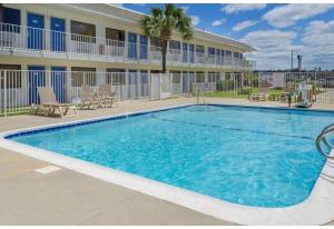 a large swimming pool in front of a hotel at Motel 6 Gulfport, MS Airport in Gulfport