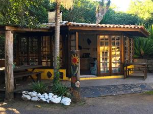 a small building with a bench and a table at Pousada Beira Mar in Garopaba
