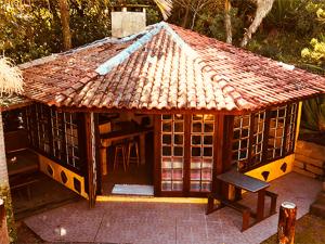 a small house with a roof on a patio at Pousada Beira Mar in Garopaba