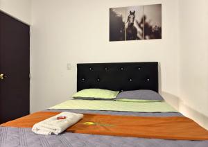 a bedroom with a bed with a black headboard at Hotel Alcaraván Aguazul in Aguazul
