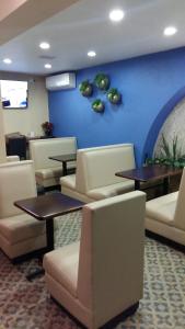 a waiting room with tables and chairs and a blue wall at Hotel La Merced in Colima