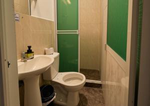 a bathroom with a white toilet and a sink at Hotel Alcaraván Aguazul in Aguazul +10 photos