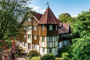 an old house with a turret in the forest at Romantik Hotel Hof zur Linde in Münster