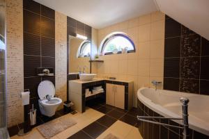 a bathroom with a tub and a toilet and a sink at Casa Leda in Sovata +17 photos