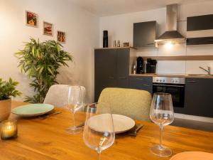 a wooden table with wine glasses on top of it at GoldPath Classic Apartment - Marktplatz Waldkirchen in Waldkirchen +41 photos