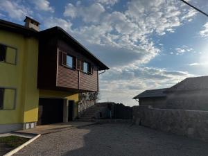 a yellow house with a stone wall at Rumena hiša in Trnovo