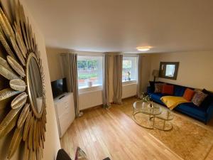 a living room with a blue couch and a table at Riverside 2 Bedroom Apartment - Central Location in Kingston upon Thames