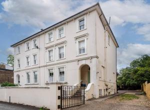 a white building with a gate in front of it at Riverside 2 Bedroom Apartment - Central Location in Kingston upon Thames