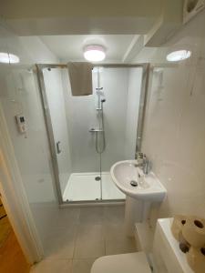 a white bathroom with a shower and a sink at Riverside 2 Bedroom Apartment - Central Location in Kingston upon Thames +18 photos
