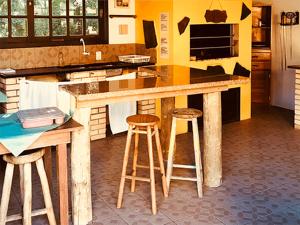 a kitchen with a counter and stools in a kitchen at Pousada Beira Mar in Garopaba +6 photos