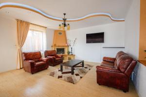 a living room with two leather chairs and a table at Casa Leda in Sovata