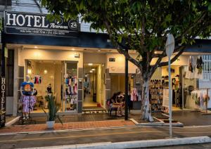a store on a street with a person sitting in front of it at Hotel Alcaraván Aguazul in Aguazul