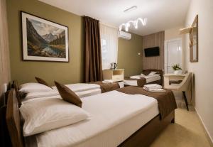 ein Hotelzimmer mit drei Betten und einem Schreibtisch in der Unterkunft MarNar Hotel in Yerevan + 97 Fotos