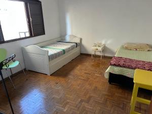 a small bedroom with two beds and a window at Pousada e Hostel Rodo in São Carlos