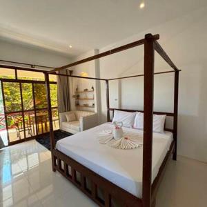 a bedroom with a canopy bed and a living room at ROHO-Residence in Nungwi