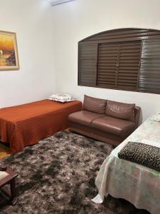a room with a bed and a couch and a bed and a chair at Pousada e Hostel Rodo in São Carlos
