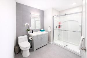 a bathroom with a shower and a toilet and a sink at Modern Yale Loft Best Location Parking in New Haven