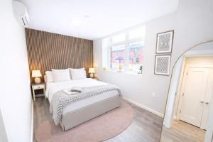 a white bedroom with a bed and a mirror at Modern Yale Loft Best Location Parking in New Haven