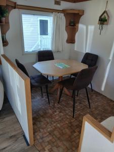 a dining room table and chairs in a room at Cosy family friendly static in Pistyll