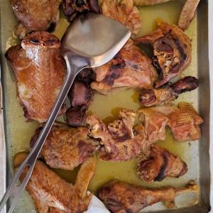 a pan of chicken wings with a spoon in it at Hotel Restorant Riza in Tirana