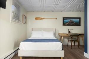a bedroom with a bed and a desk with a chair at The Beachside Co in Sylvan Beach