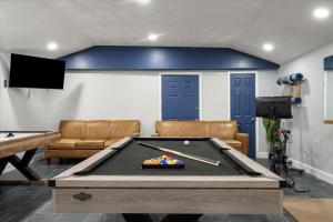 a living room with a pool table and a tv at The Beachside Co in Sylvan Beach