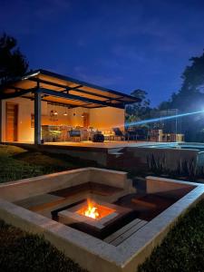 a fire pit in front of a house at night at Hop Village in Praia do Rosa