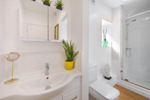 a white bathroom with a sink and a toilet at Chic 1BR Teddington Apartment Modern & Bright in Kingston upon Thames +41 photos