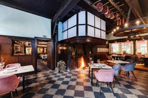 a restaurant with tables and chairs and a fireplace at Romantik Hotel Hof zur Linde in Münster