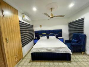a bedroom with a bed and a blue chair at Paradise Creek Hotel in Tamale