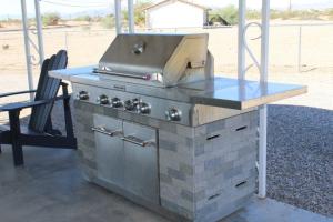 an outdoor grill with a table and a grill at The Round House in Parker