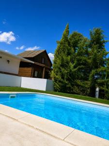 a blue swimming pool in front of a house at Villa Soñada Setenil in Setenil