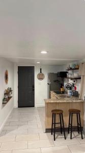 a kitchen with two stools and a counter in a room at Small Space Charm in Tampa +1 photo