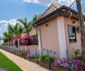 a house with flowers in front of a fence at Paradise Creek Hotel in Tamale