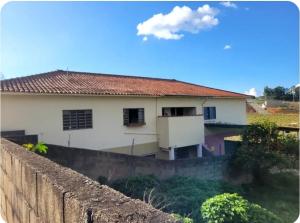 a house behind a retaining wall and a fence at Pousada Welsh in Bueno Brandão +2 photos