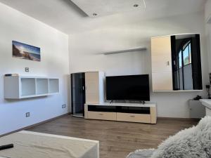a white living room with a flat screen tv at Fewo Tanja in Bestwig