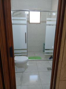 a bathroom with a toilet and a glass shower at بيت مريم in Irjān