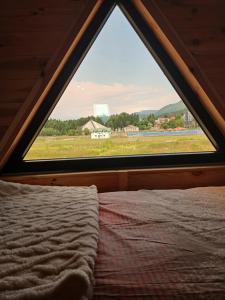a bedroom with a bed and a large window at Chalet Anika in Kolašin