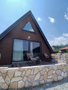 a house with a patio with two chairs on it at Chalet Anika in Kolašin