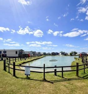 a body of water with houses and a fence at Maisy's Retreat in Chapel Saint Leonards