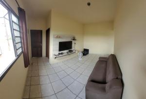 a living room with a couch and a flat screen tv at Pousada Welsh in Bueno Brandão