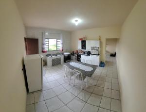 a kitchen with a table and a white refrigerator at Pousada Welsh in Bueno Brandão
