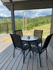 a table and chairs on a deck with a view at Gora vitriv in Slavske