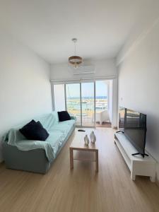 a white living room with a couch and a table at Harbour No4 in Polis Chrysochous