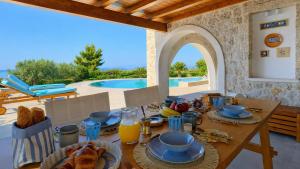 a table with breakfast food and a view of a pool at Villa Athena Ermioni in Ermioni