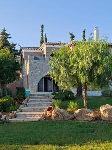 a house with stairs and a tree in front of it at Villa Athena Ermioni in Ermioni
