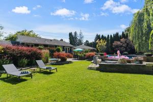 a yard with two chairs and a fountain at Waterfront Oasis with Pool, Hot Tub & Pet Friendly in Kelowna