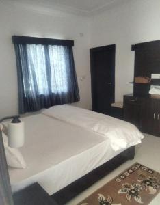 a bedroom with a white bed and a window at Hostel Arabbian nights in Khajurāho +13 photos